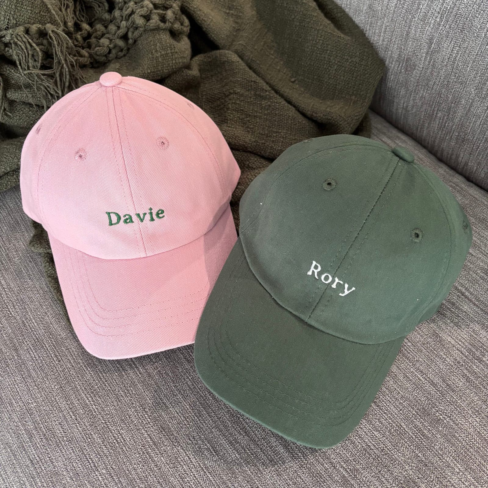 Pink and green caps embroidered with the names Davie and Rory